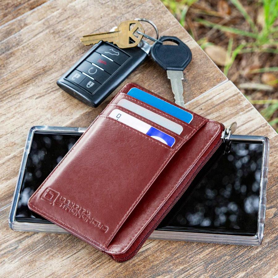 Red RFID-blocking mini wallet next to every day carry items highlighting its compact design and stylish appearance. The wallet is shown with its secure closure and multiple compartments, making it a practical accessory for organizing essentials like credit cards, IDs, and cash while on the go.